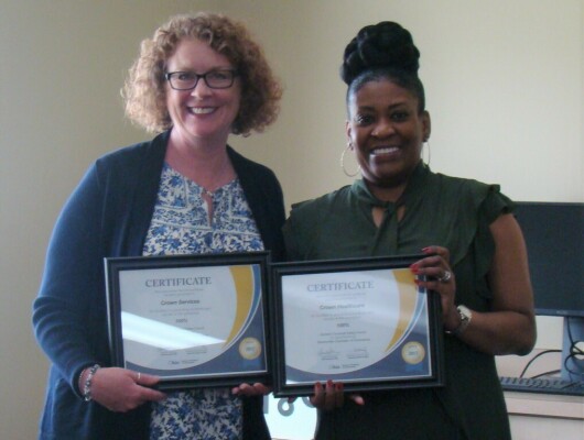 Two woman holding two certificates